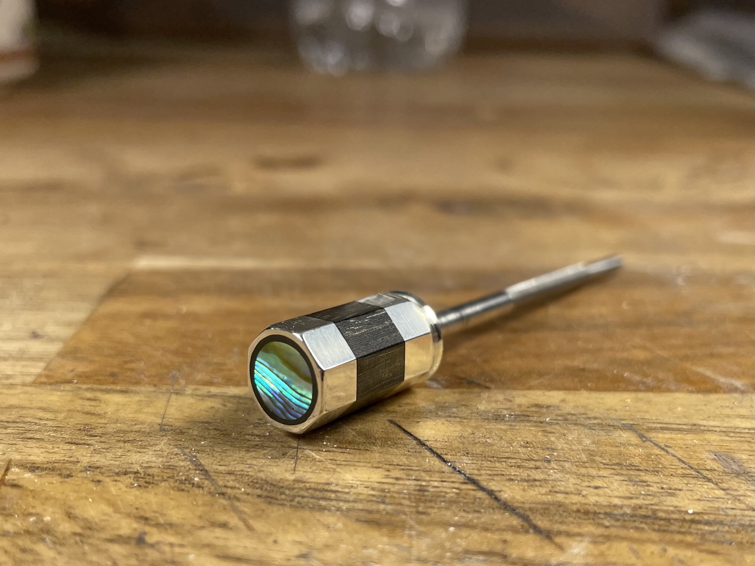 Facets are then filed into the button by hand at which point I’ll inlay the pearl into the end as well. The facets are then sanded down to 3000 grit and polished.