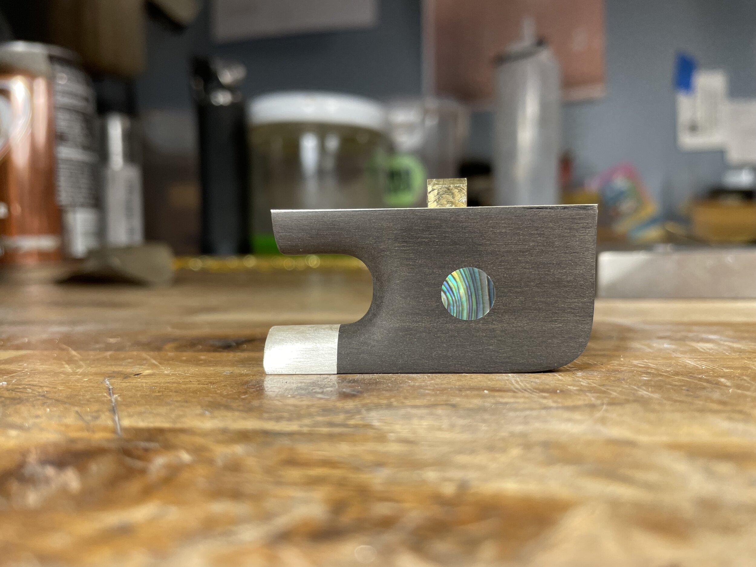 The brass eyelet and pearl eyes are then put in. The sides and profile are also shaped at this time. I’ll take a moment here to look at my spec sheet and make sure I’m following my model’s profile.